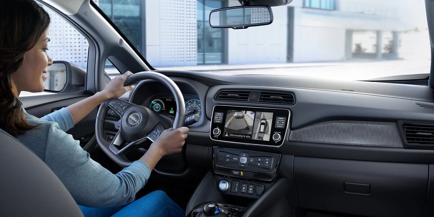 Femme au volant de la Nissan Leaf 2024.